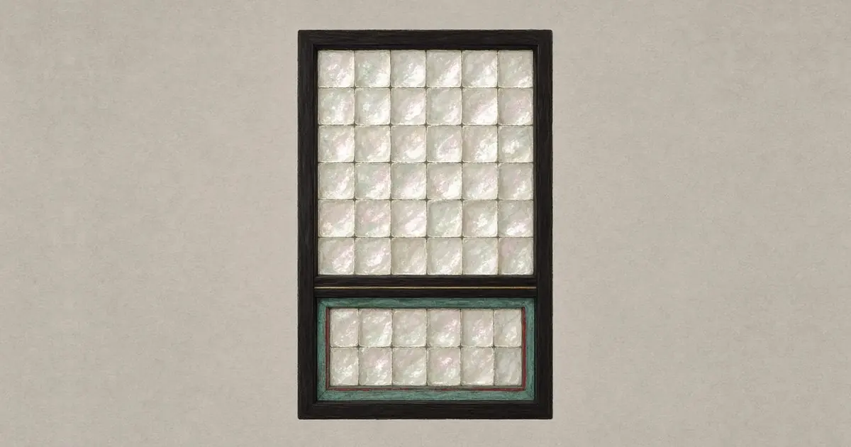 A tall window in a dark frame: a large grid of plain shell tiles above a wooden crossbar, and a smaller two-row grid below it set in a verdigris-green frame with a thin red inner border.